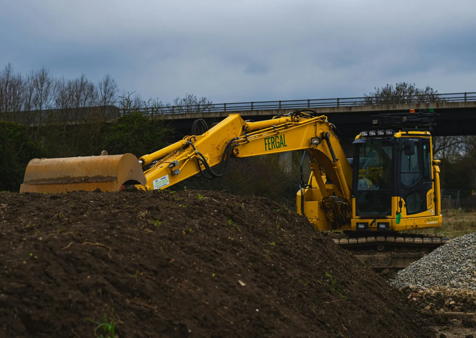 Photo of a yellow excavator next to a pile of soil, for a post on Angi and Thumbtack leads