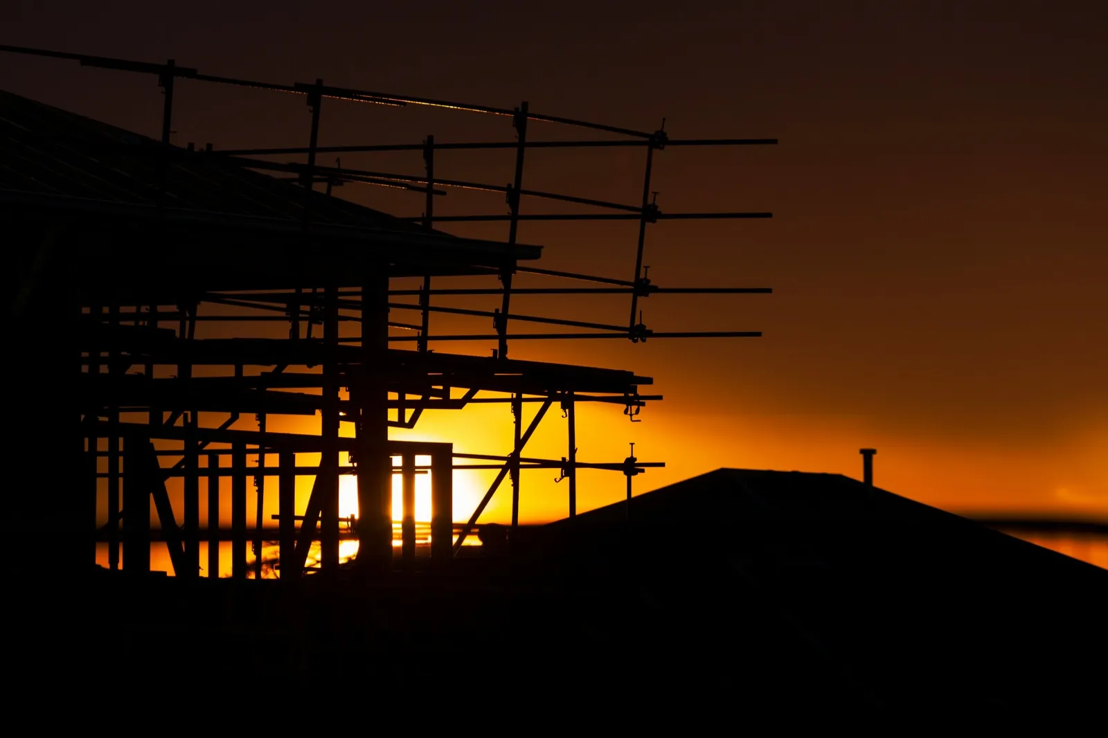 Photo of scaffolding on a house under construction at sunset, the kind of local job contractor marketing helps you win