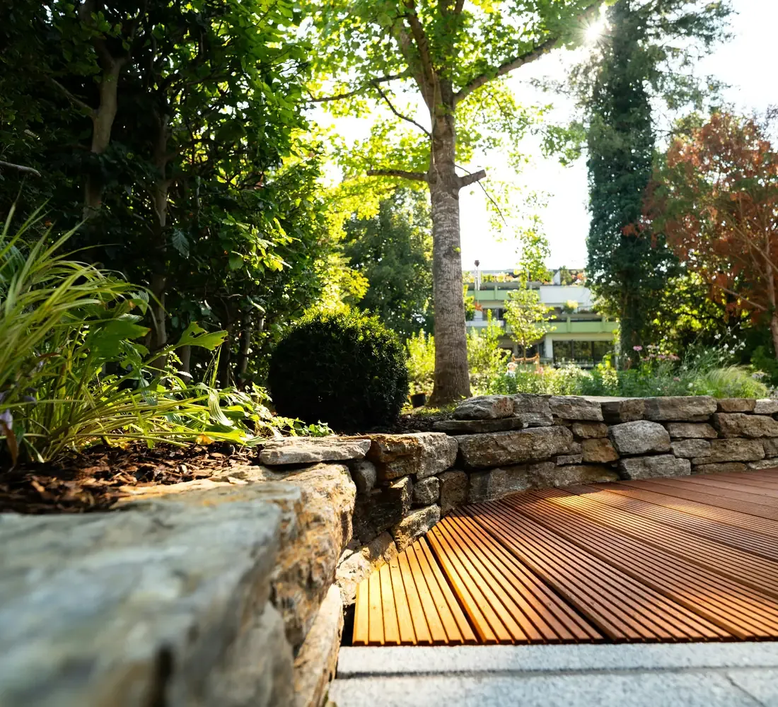 Photo of a finished wood deck beside a stone garden wall, the kind of project a contractor website checklist says to show