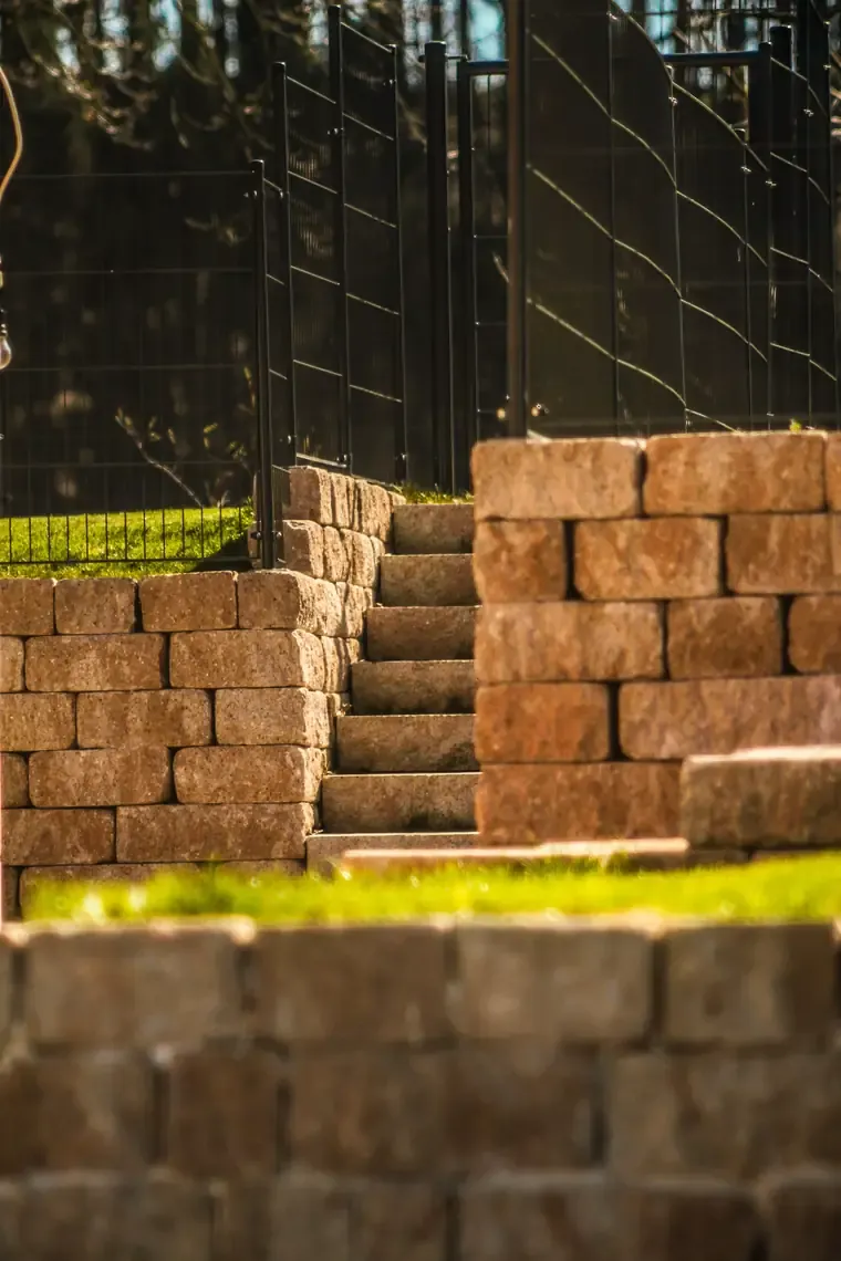 Photo of a stacked block retaining wall with stone steps, finished work that earns Google reviews
