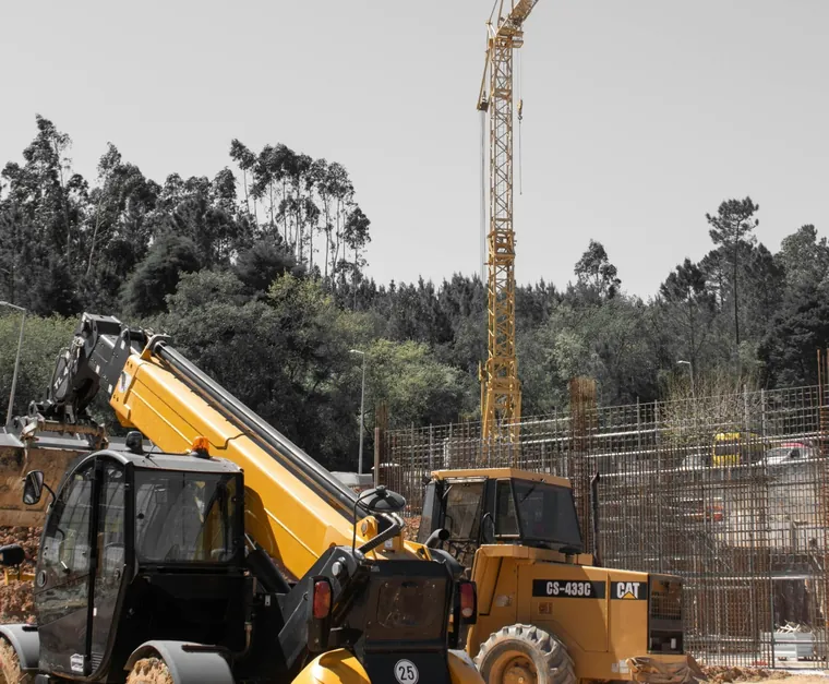 Photo of a telehandler and a loader on a construction site with a crane behind, for a Google Business Profile guide for contractors