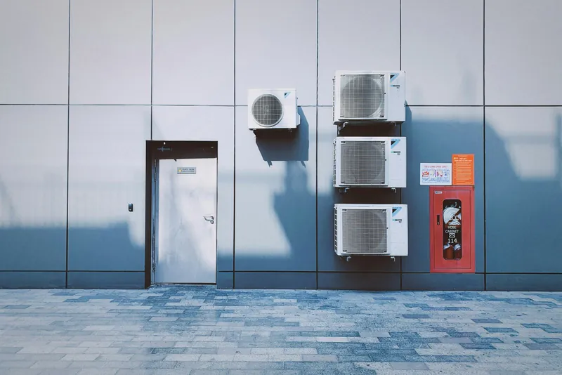 Photo of outdoor air conditioning units mounted on a building wall